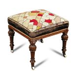 An early Victorian satin walnut stool upholstered in a period woolwork needlepoint, on fluted legs