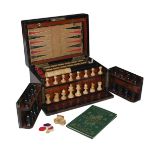 A Victorian walnut games compendium, the hinged lid and double-hinged front enclosing a turned