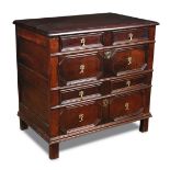 A James II oak chest of drawers, with geometric moulded drawer fronts and walnut veneered panels,