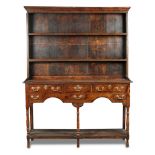 A small Regency oak dresser, with raised boarded plate rack and fitted three small drawers,