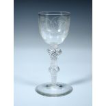 A Jacobite 'Fiat' air twist wine glass, the rounded bowl engraved with an oak leaf, rose and two