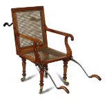 A 19th century Satin birch patent invalid chair, with caned seat and back panels, folding steel