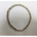 A 9ct white gold and multi gem line bracelet, set as a continuous line of round cut hardstones