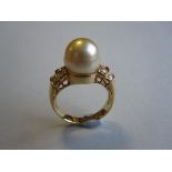 A pearl and diamond ring, set to the centre with a 10.2 mm diameter x 10.7mm high pearl of pale