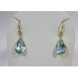 A pair of 18ct gold and blue topaz drop earrings, each wire hook suspending a spectacle set pear cut