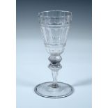 An 18th century soda glass, the conical bowl cut with facets and milled bands, the double knopped