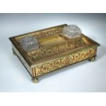 A 19th century cut brass and rosewood desk stand, the central brass well flanked by replacement