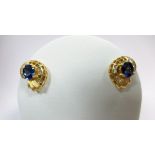 A pair of 18ct gold tanzanite and diamond earstuds, each designed as a pierced spiral sea shell with