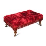 A Victorian oak framed stool, button upholstered in a crimson fabric, on turned legs and casters