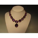 A Victorian amethyst rivière necklace with pendant drop, comprising nineteen graduated oval cut