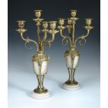 A pair of ormolu and white marble candelabra, each with four branches rising above ovoid white