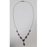 A late Victorian amethyst and seed pearl necklace, set to the front with a graduated line of oval