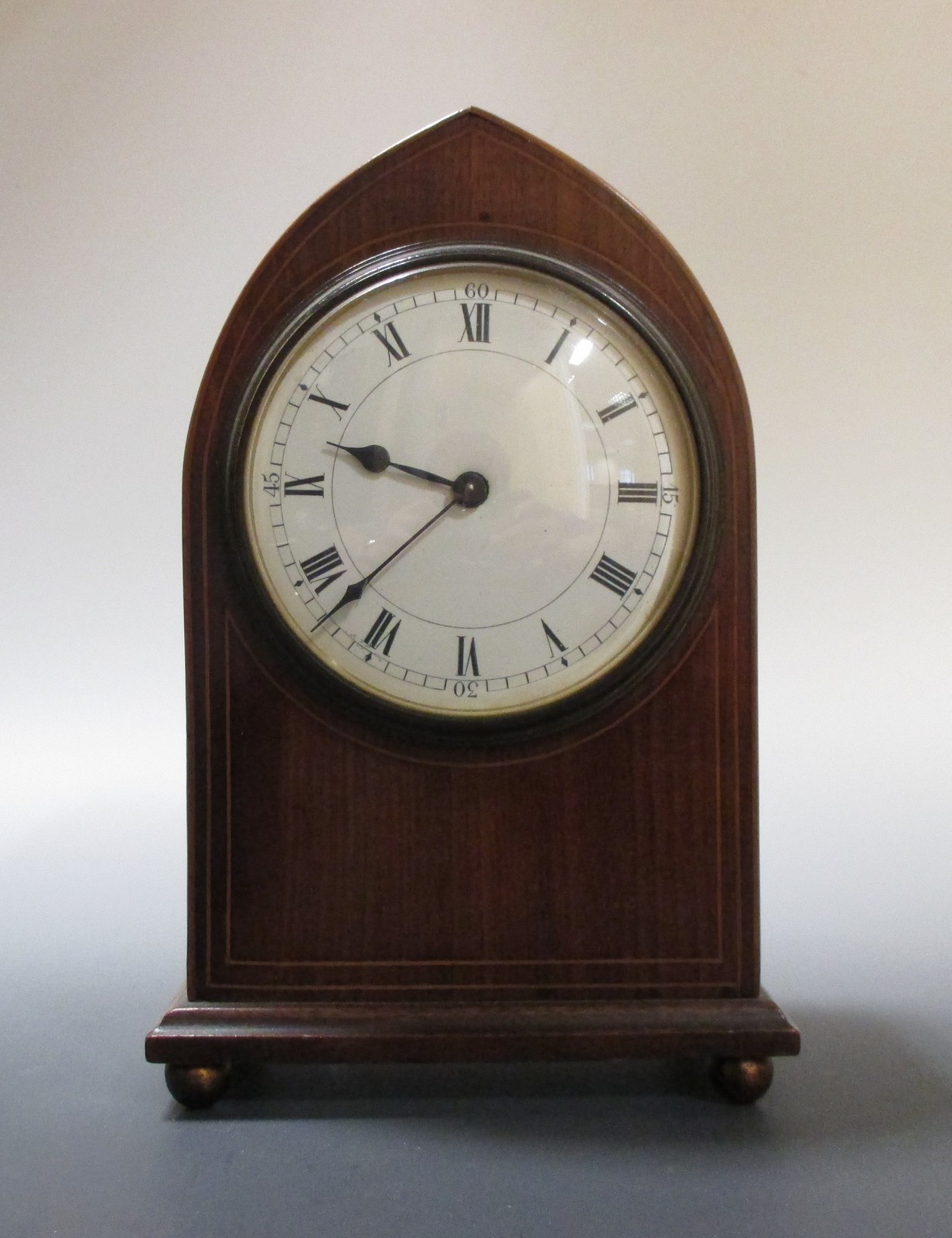 Two arched case mahogany mantel clocks and an oak mantel clock (3)