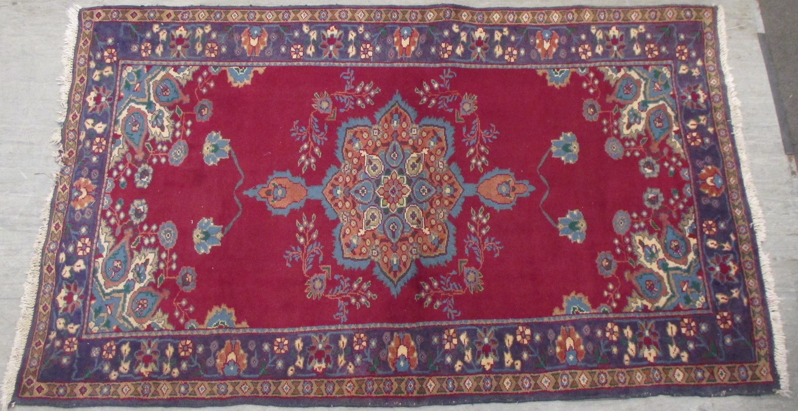 A modern Persian red ground rug with central floral lozenge and carnation emblazoned border, 215 x