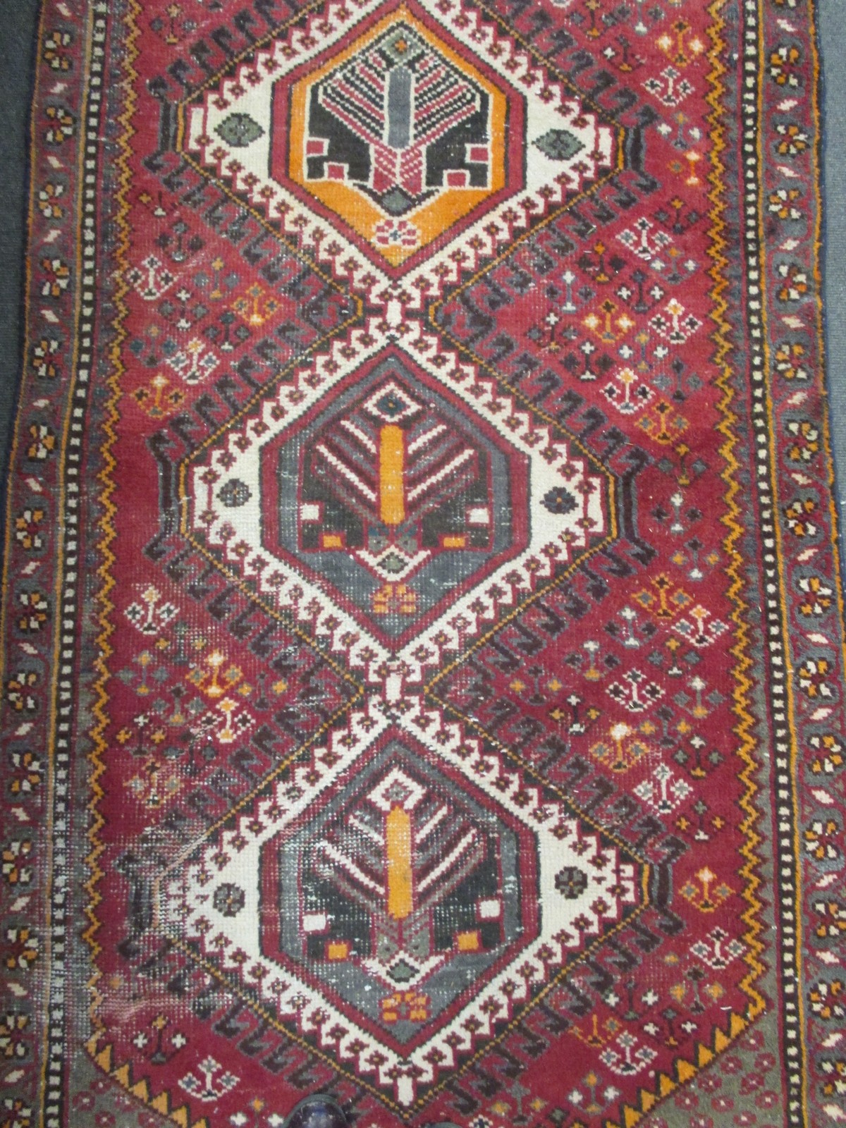 A Turkish runner on a red ground with a floral border, 300 x 95cm