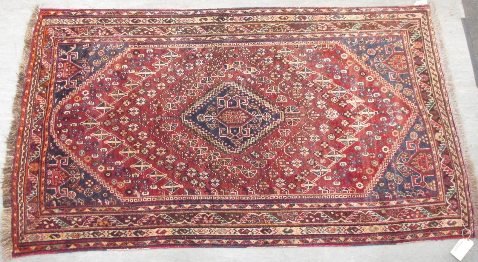 A Caucasian red ground carpet with yellow border, 203 x 134cm and four other rugs, (5)