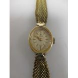 A lady's gold plated 'Tudor' wristwatch, oval bezel, champagne coloured dial with baton numerals,