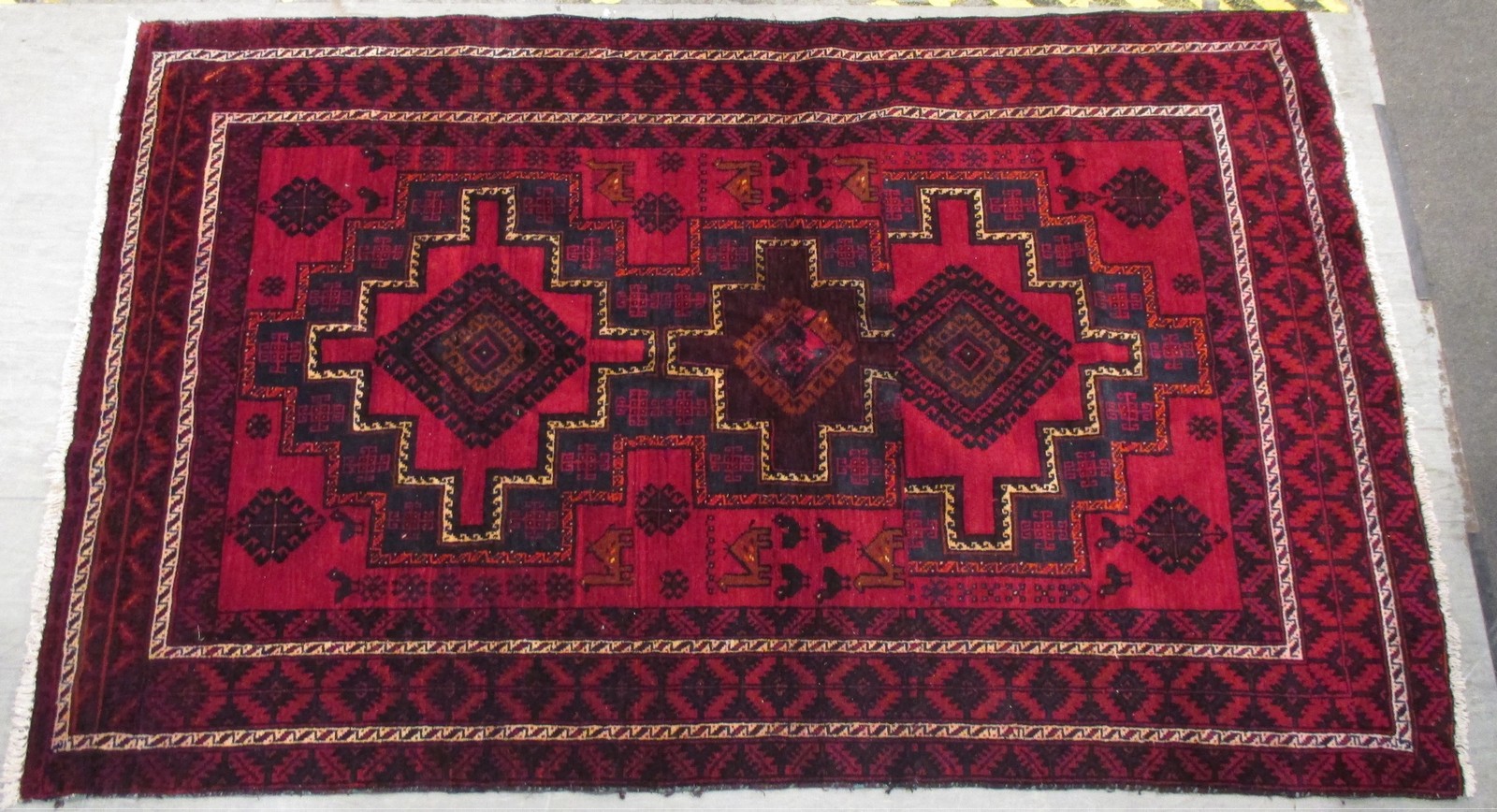 A Turkish rug on a red ground with multiple borders, 235 x 152cm