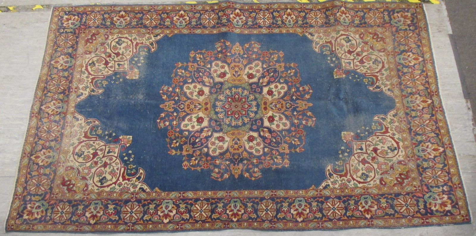 A Persian rug on a blue ground, with a floral central medallion and floral border, 236 x 137cm