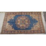 A Persian rug on a blue ground, with a floral central medallion and floral border, 236 x 137cm