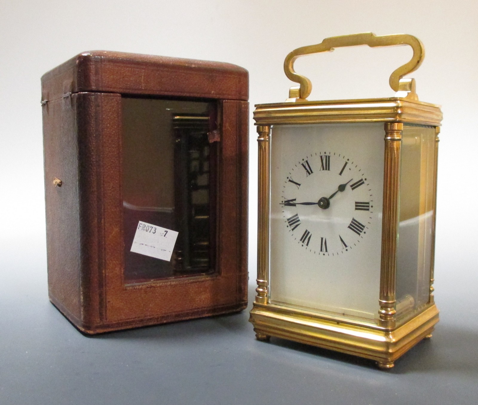 An oval brass carriage clock, and another with leather travel case
