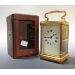 An oval brass carriage clock, and another with leather travel case