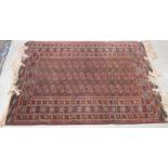 A Tekke rug on a red ground, 184 x 128cm together with two others, 140 x 96cm, 140 x 82cm (3)