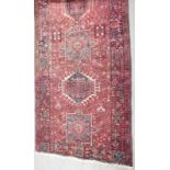 A Turkish red ground rug with multiple borders, 440 x 143cm