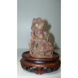 A 19th century soapstone group of a lady gathering cherry blossoms, she holds a branch, a basket