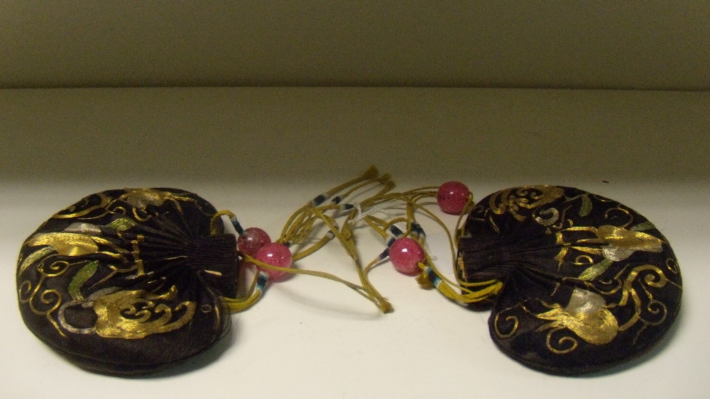 A pair of embroidered black silk purses, the heart shapes worked in gold threads with finger