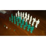 A late 19th/early 20th green and white ivory chess set in mahogany box, the pawns carved as