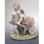 A porcelain figure of a putti, pulling a cart