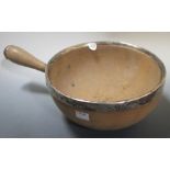 A 19th century turned wooden bowl, with silver mount and side handle, bold initials AH to the
