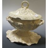 An early 19th century creamware sauce tureen on stand, together with a sauce boat, pickle dish a