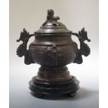 A Chinese bronze censer and cover, on a wooden base