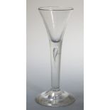 An 18th century wine glass with teared stem and trumpet bowl on circular foot, 17cm (6.75 in) high