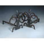 After Gilbert Poillerat, a pair of wrought iron fire dogs, each of entwined scroll work, unmarked 34