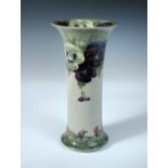 A Moorcroft pansy pattern vase, the tall cylindrical form with flared rim, painted and impressed