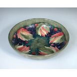 A Moorcroft leaves and berries pattern bowl, of circular form decorated to a green ground, painted