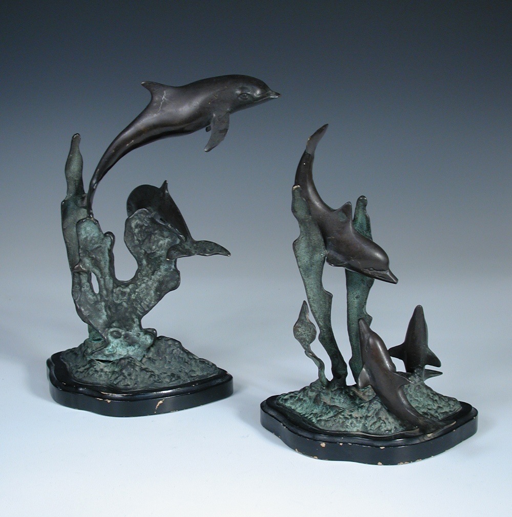 A 20th century bronze group of a pair of dolphins, modelled with one swimming above the other,