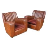 A pair of 1930's Art Deco brown leather upholstered club armchairs, the dark tan leather backs and