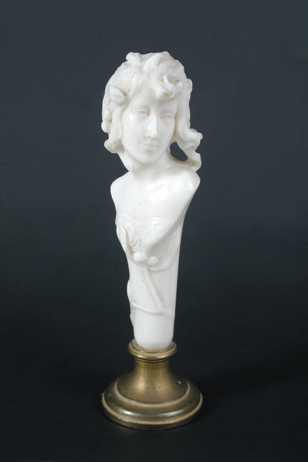 An Art Nouveau carved ivory desk seal, modelled as the torso of a maiden with long flowing locks