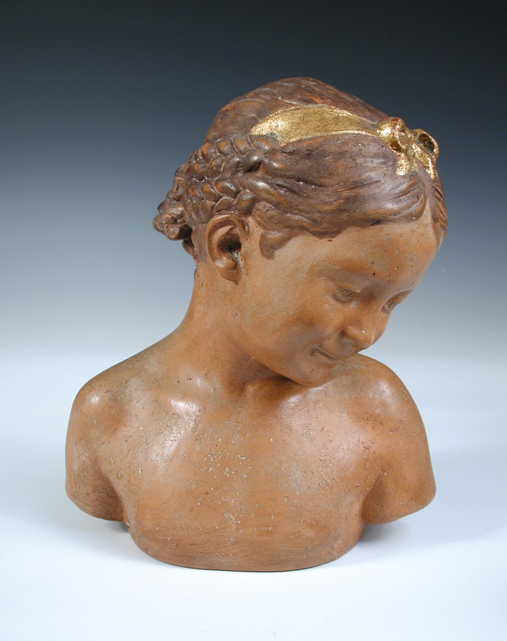 A mid 20th century Italian terracotta bust, indistinctly signed, modelled as young girl with a