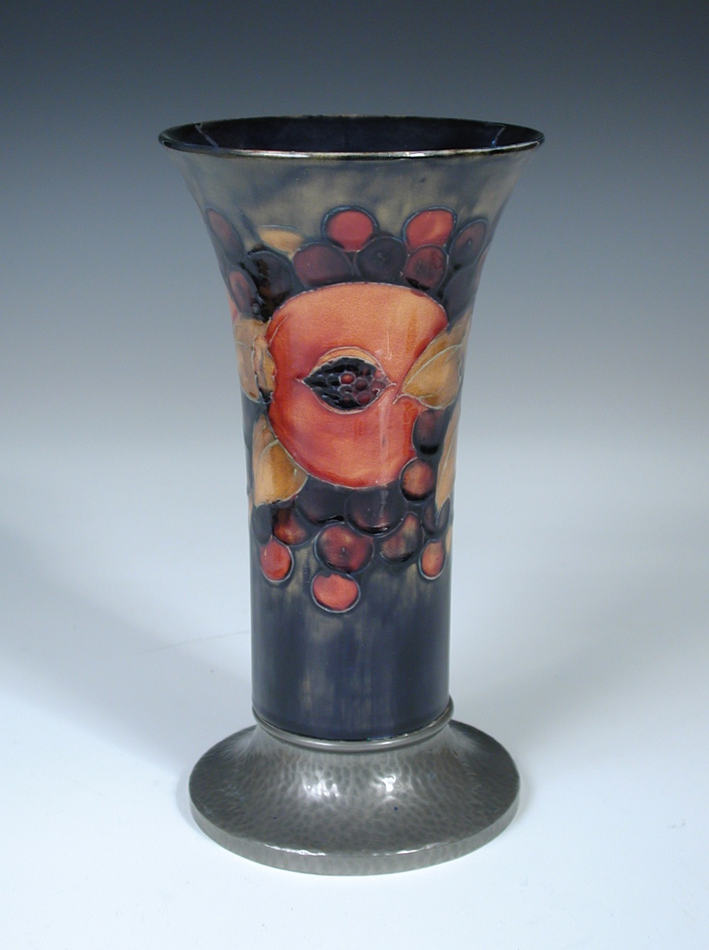 A Moorcroft pomegranate pattern trumpet vase with Tudric pewter foot, together with a Moorcroft