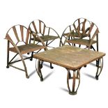A set of four craftsman made wrought iron framed garden chairs and a low table en-suite, each with a