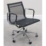 A pair of chromed swivel arm chairs after a design by Charles Eames, each with black mesh seat and