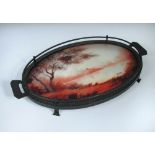 An Art Deco reverse painted and wrought iron tray, with a gallery, centred with a reverse painted