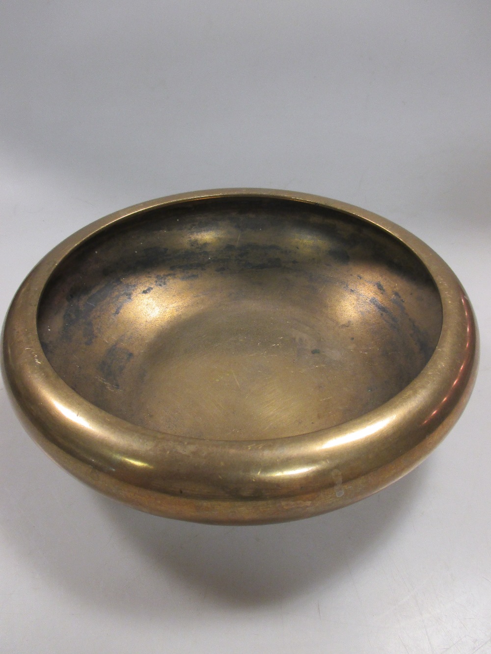 A Japanese polished bronze shallow bowl, signed Yoshimasa, 18cm diameter