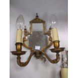 A pair of mirror backed two branch brass wall lights
