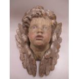 A carved wood silvered winged cherub mask